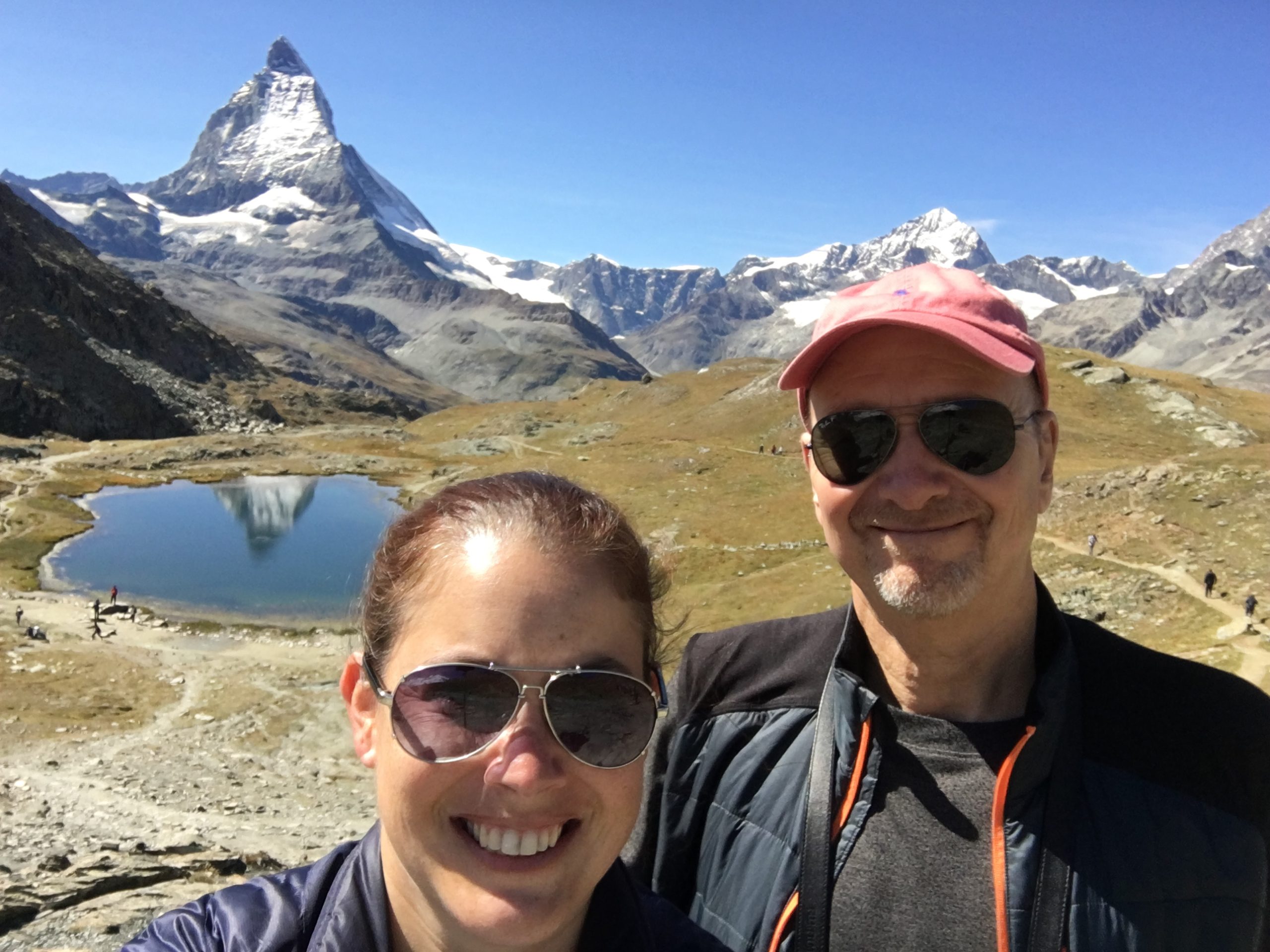 Two people in front of a Swiss landscape